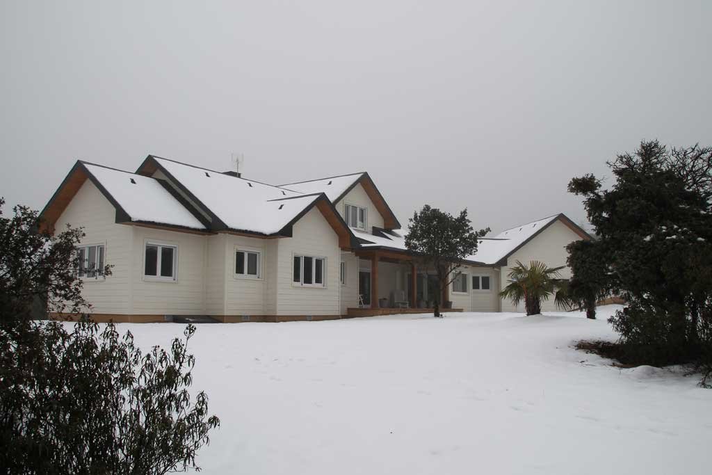Imagen de Casas de Madera Nevadas en Canexel Nieve en la fachada trasera